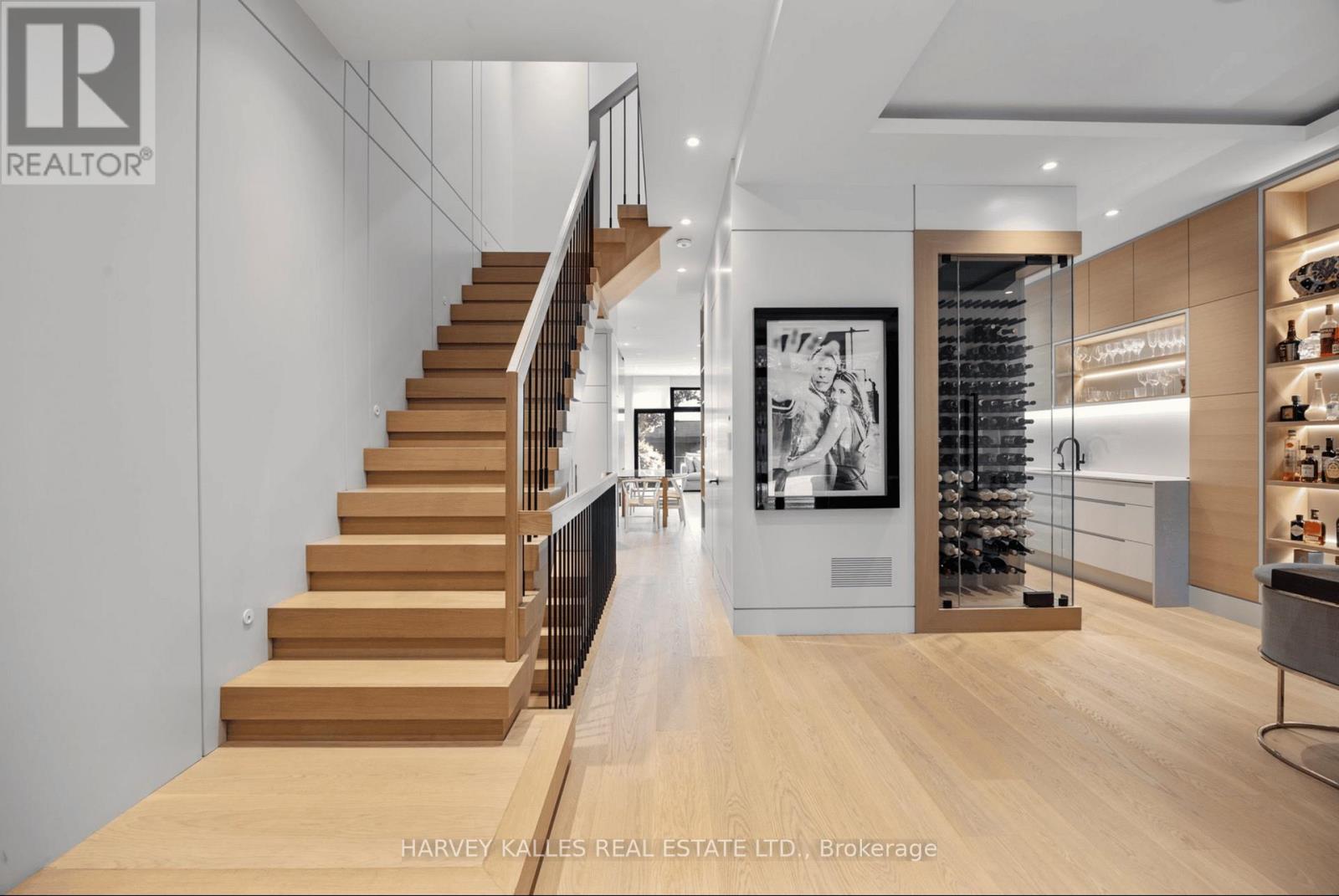 A modern interior space with a staircase, a bar area, and a framed picture on the wall.