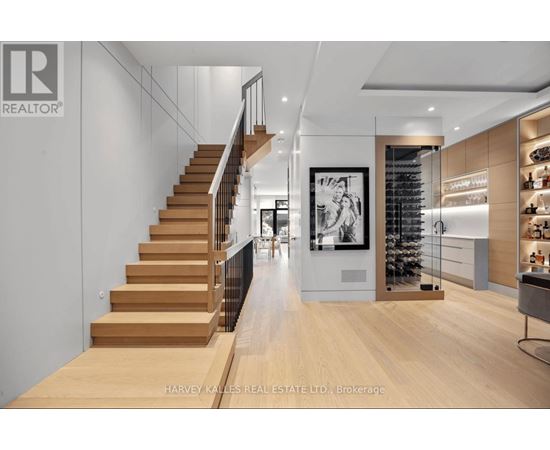 A modern interior space with a staircase, a bar area, and a framed picture on the wall.