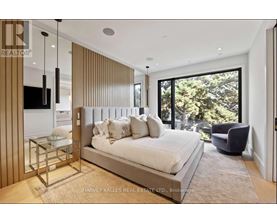 A bedroom with a large bed and a glass table.
