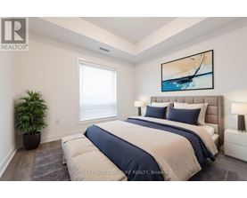 A bedroom with a large bed and a painting on the wall.