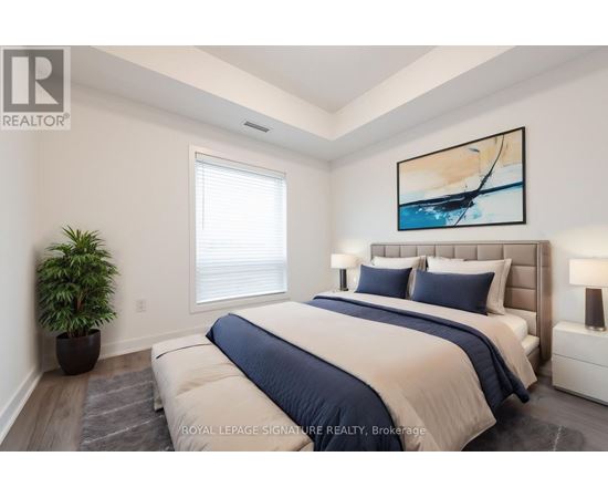 A bedroom with a large bed and a painting on the wall.