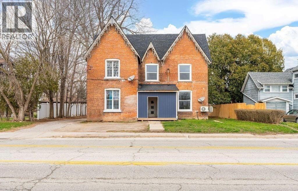 A red brick house with a blue door and windows.