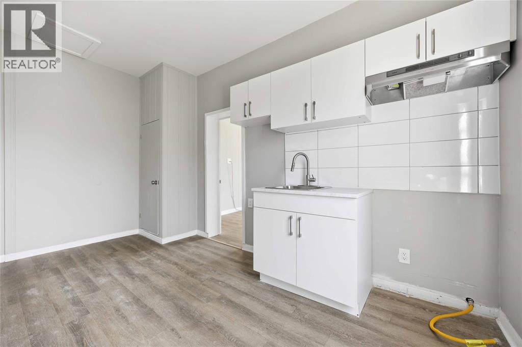 A kitchen area with white cabinets and a sink.