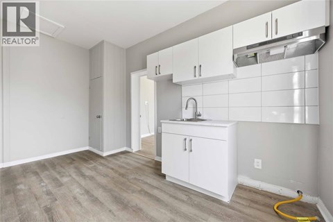A kitchen area with white cabinets and a sink.