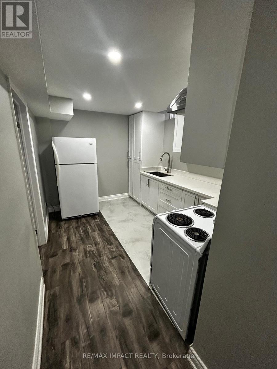 A small, modern kitchen with a white refrigerator and a white stove top oven.
