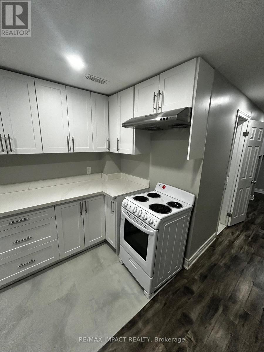 A kitchen with white cabinets and a stove top oven.