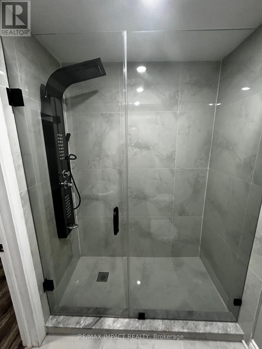 A shower with a glass door and a black handle.