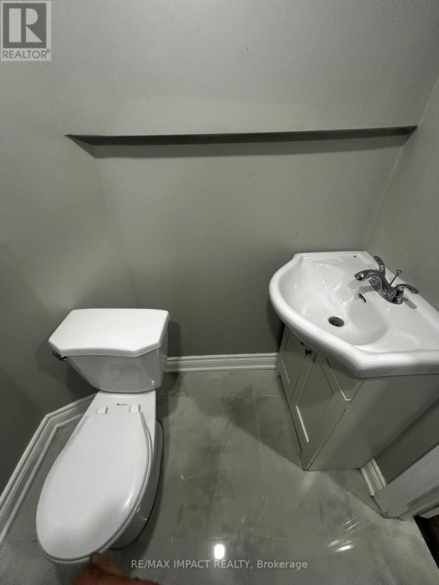 A white toilet and sink in a bathroom.