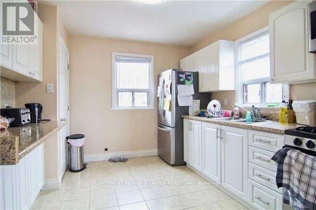 A kitchen with white cabinets and a granite counter top.