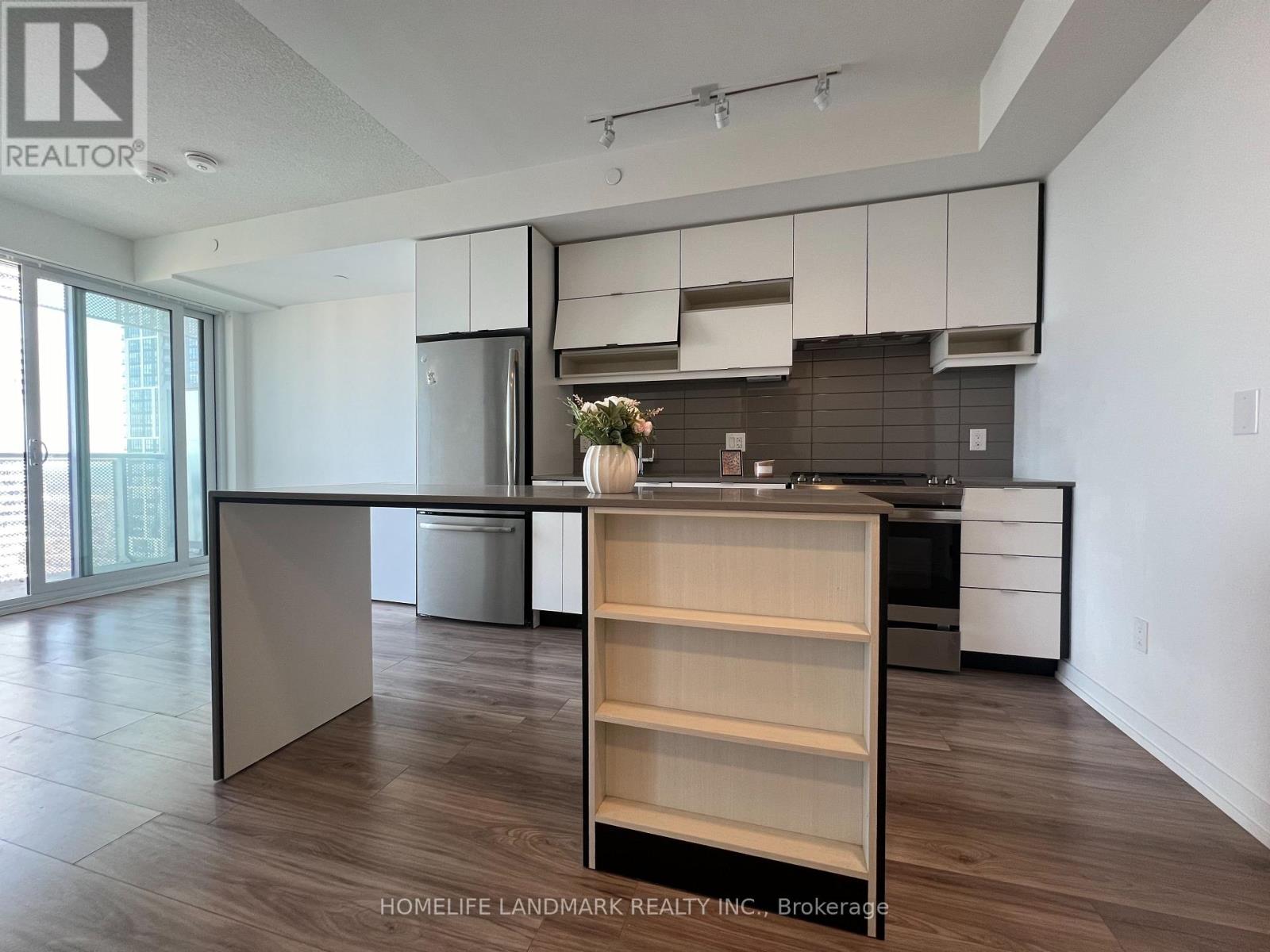 A kitchen with a wooden floor and white walls.