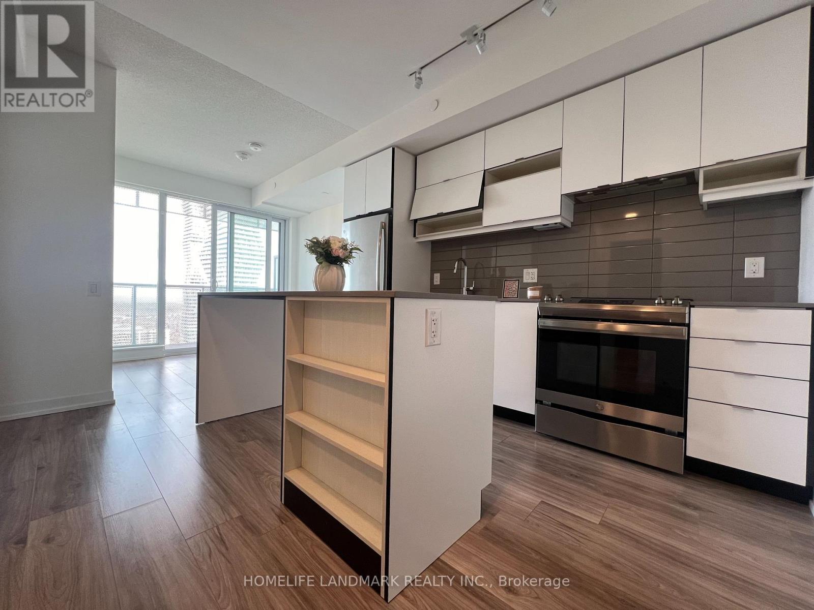 A kitchen with white cabinets and a wooden floor.