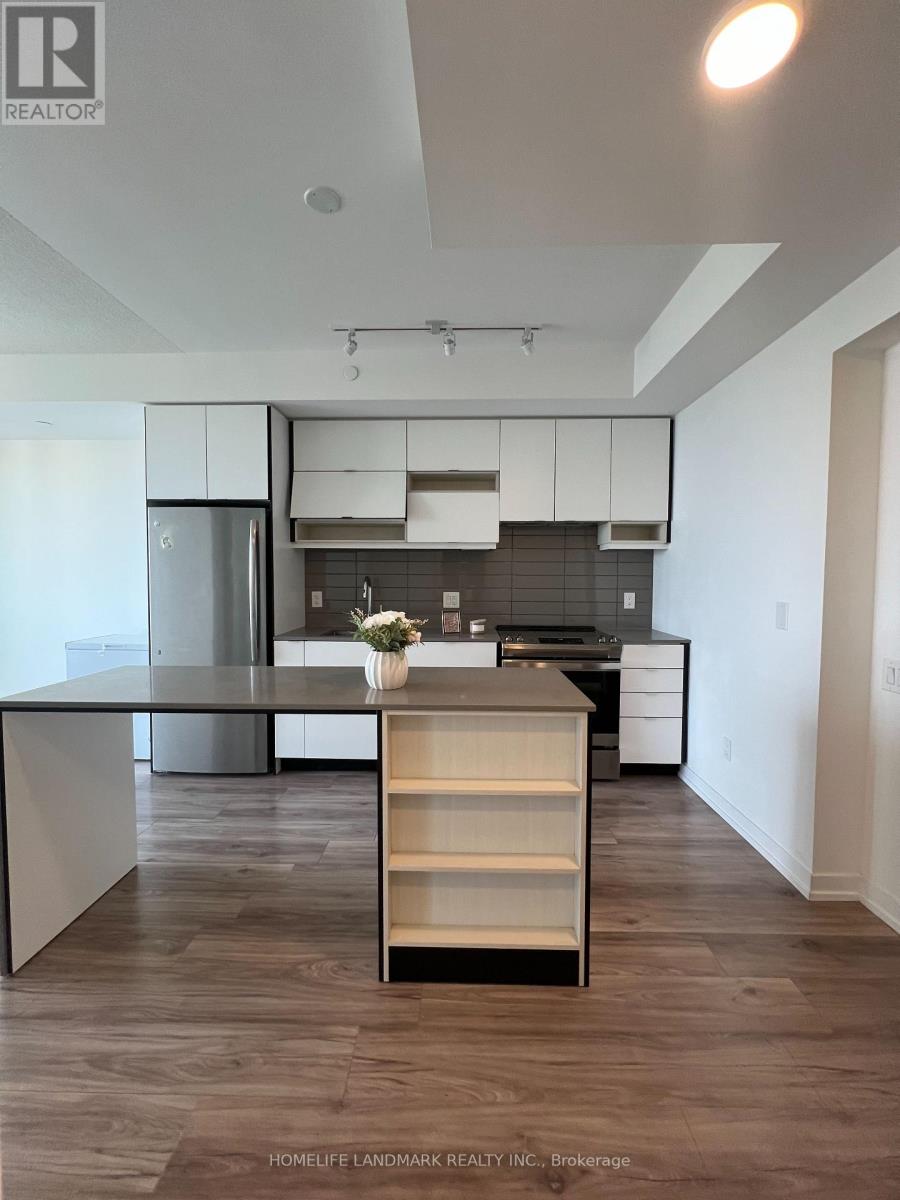 A kitchen with a white counter top and a wooden floor.