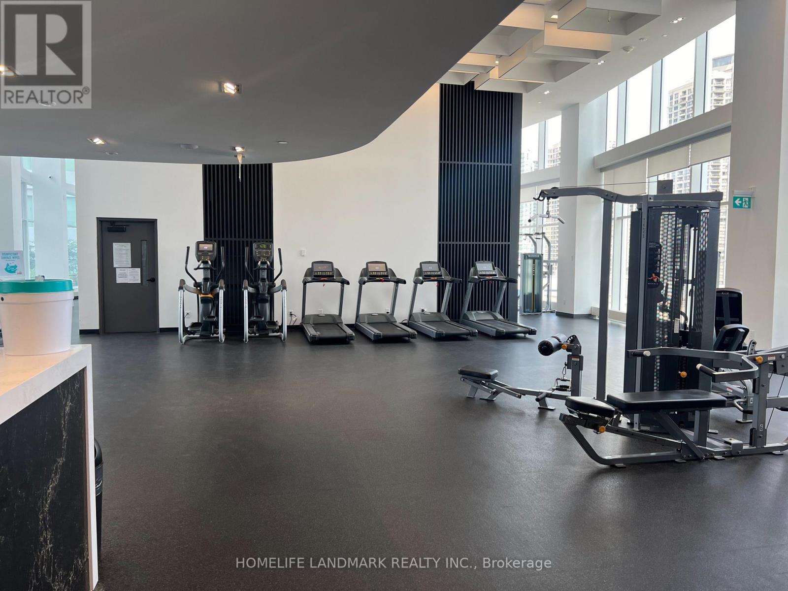 A gym with a variety of equipment including treadmills, weights, and exercise machines.