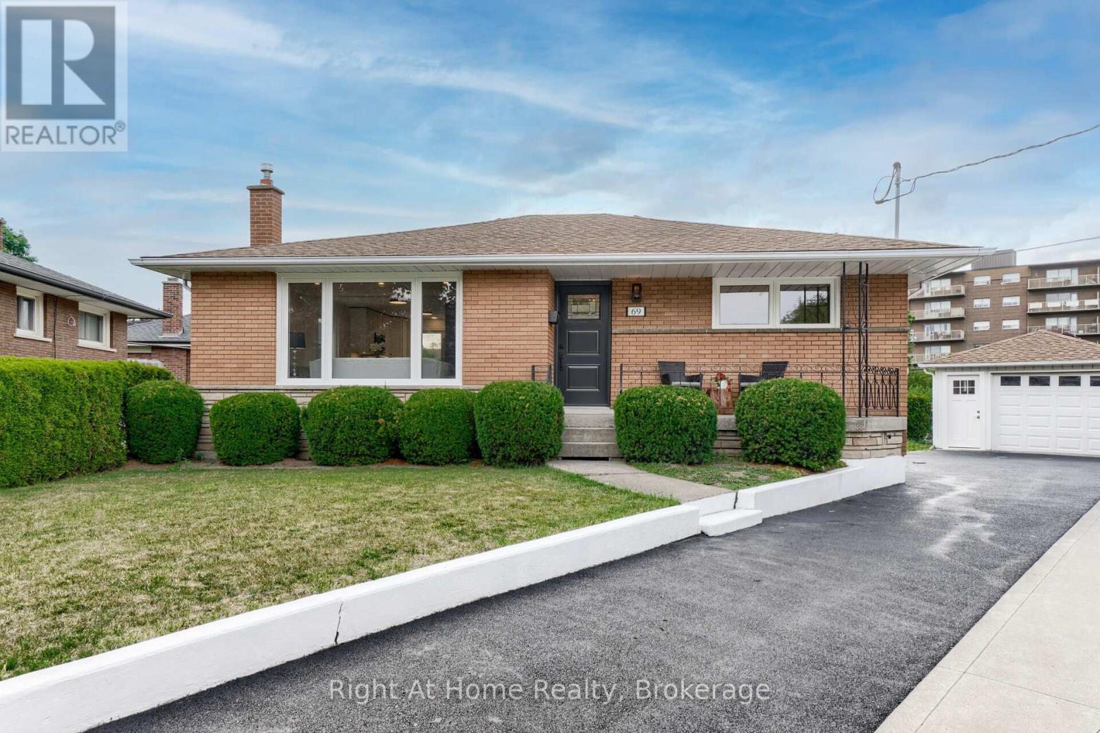 A house with a grey roof and a black door is for sale.