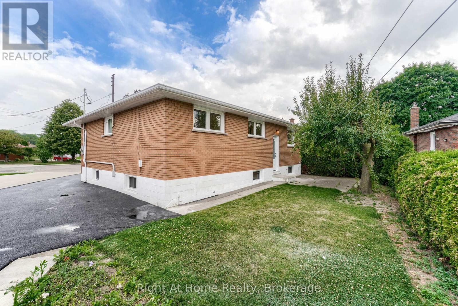 A house with a brown brick exterior and a white trim is for sale.