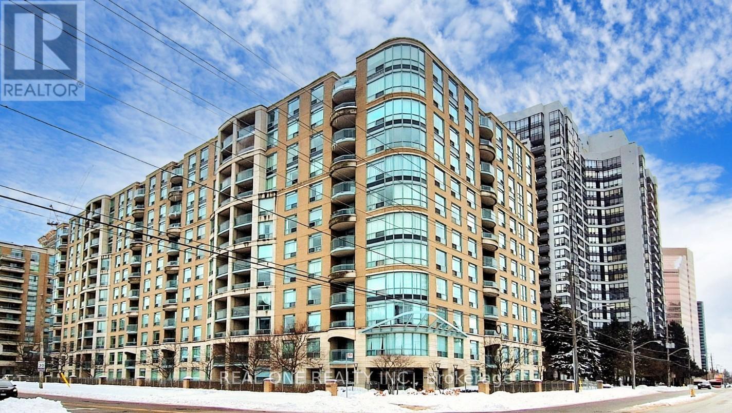 A large building with many windows is in the foreground with a blue sky in the background.