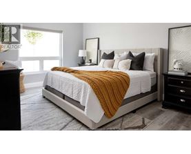 A bedroom with a large bed and a window.