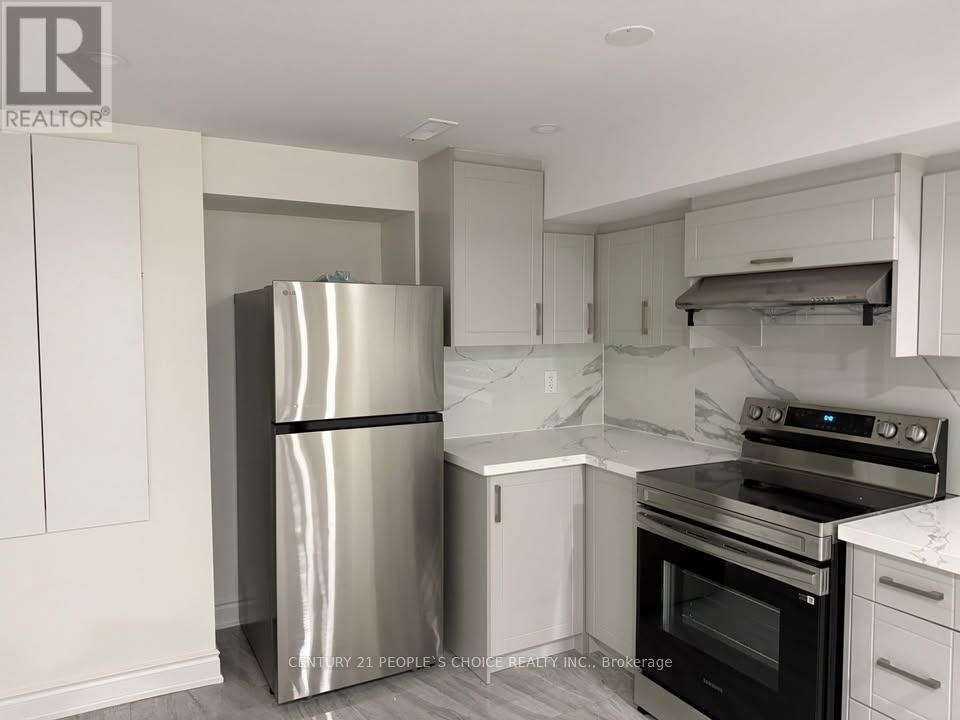 A kitchen with a stainless steel refrigerator and white cabinets.