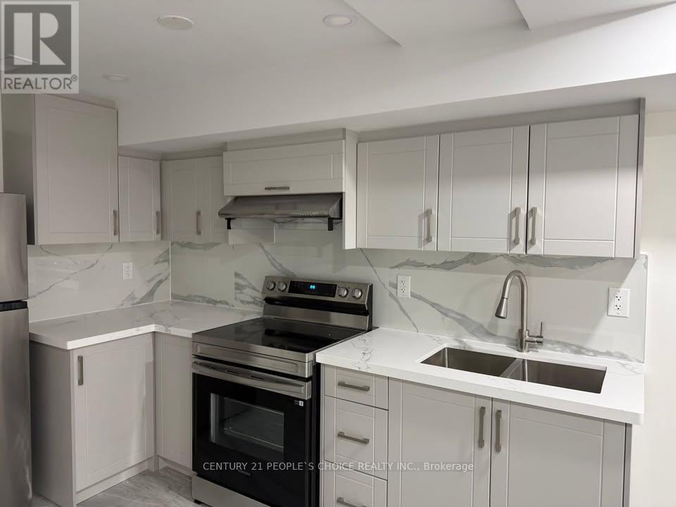 A kitchen with white cabinets and marble countertops.