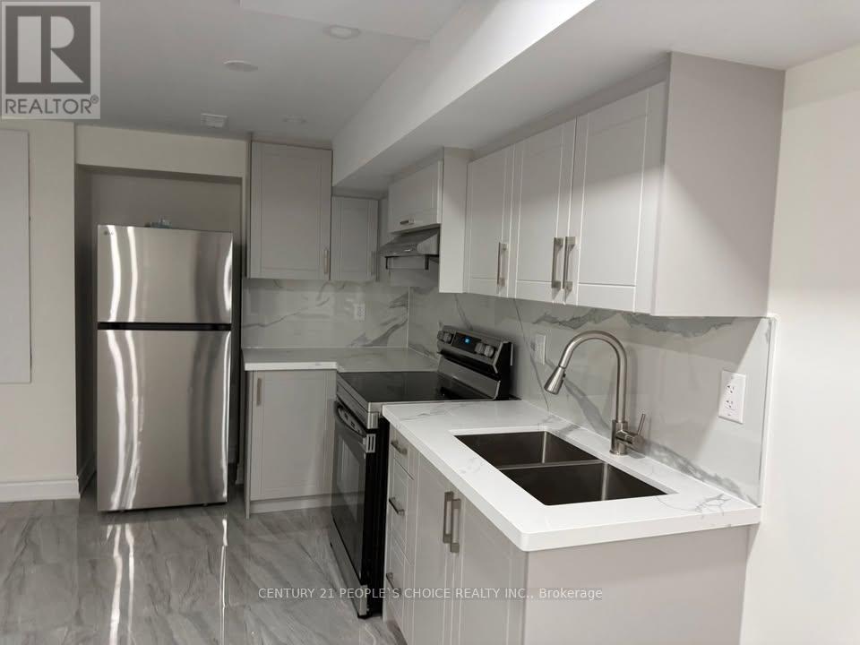A modern kitchen with a stainless steel refrigerator and white cabinets.