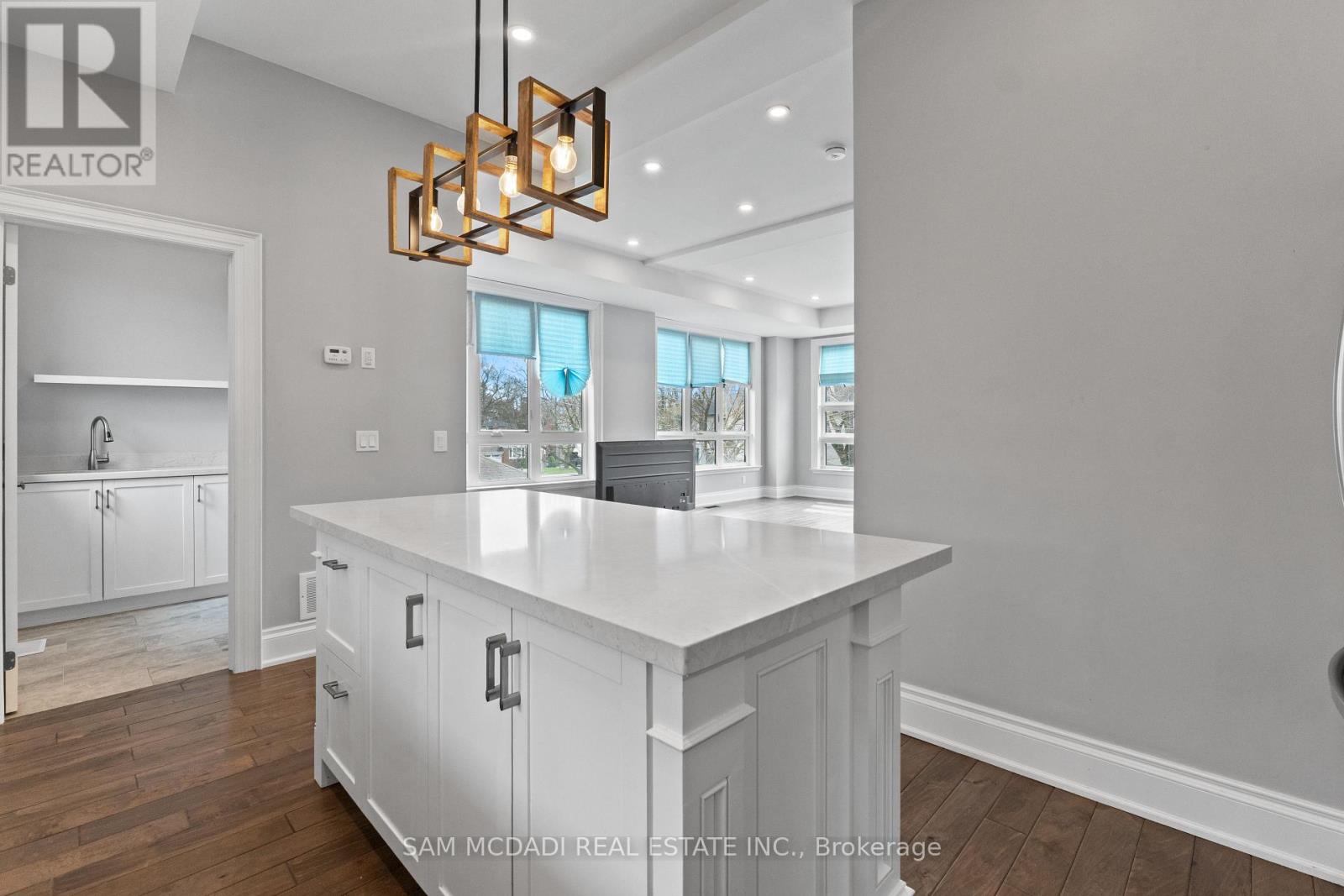 A modern kitchen with a large island and a chandelier.