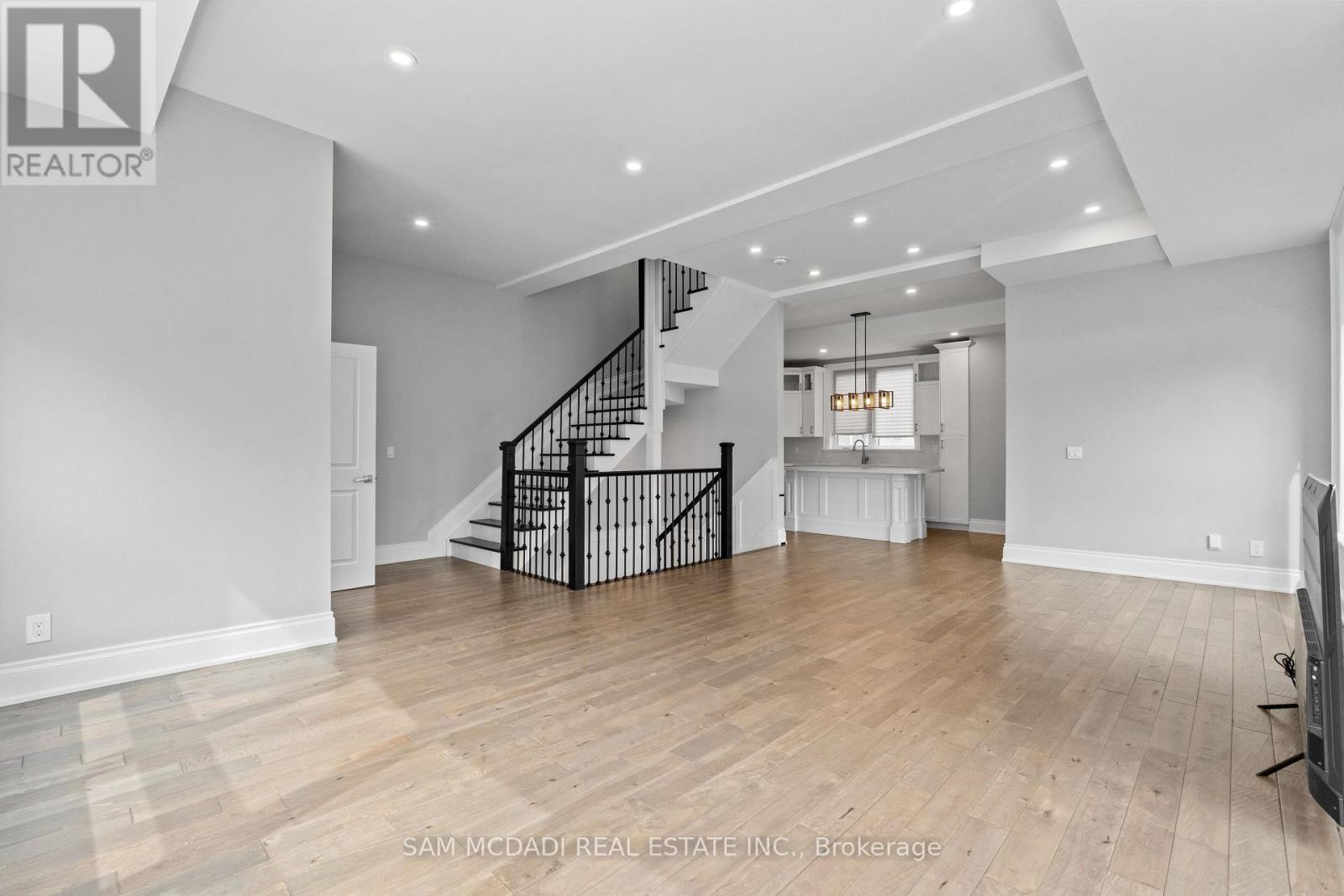 A spacious living room with a staircase and a television.