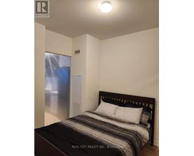 A bedroom with a bed, pillows, and a window with a view of a cityscape.