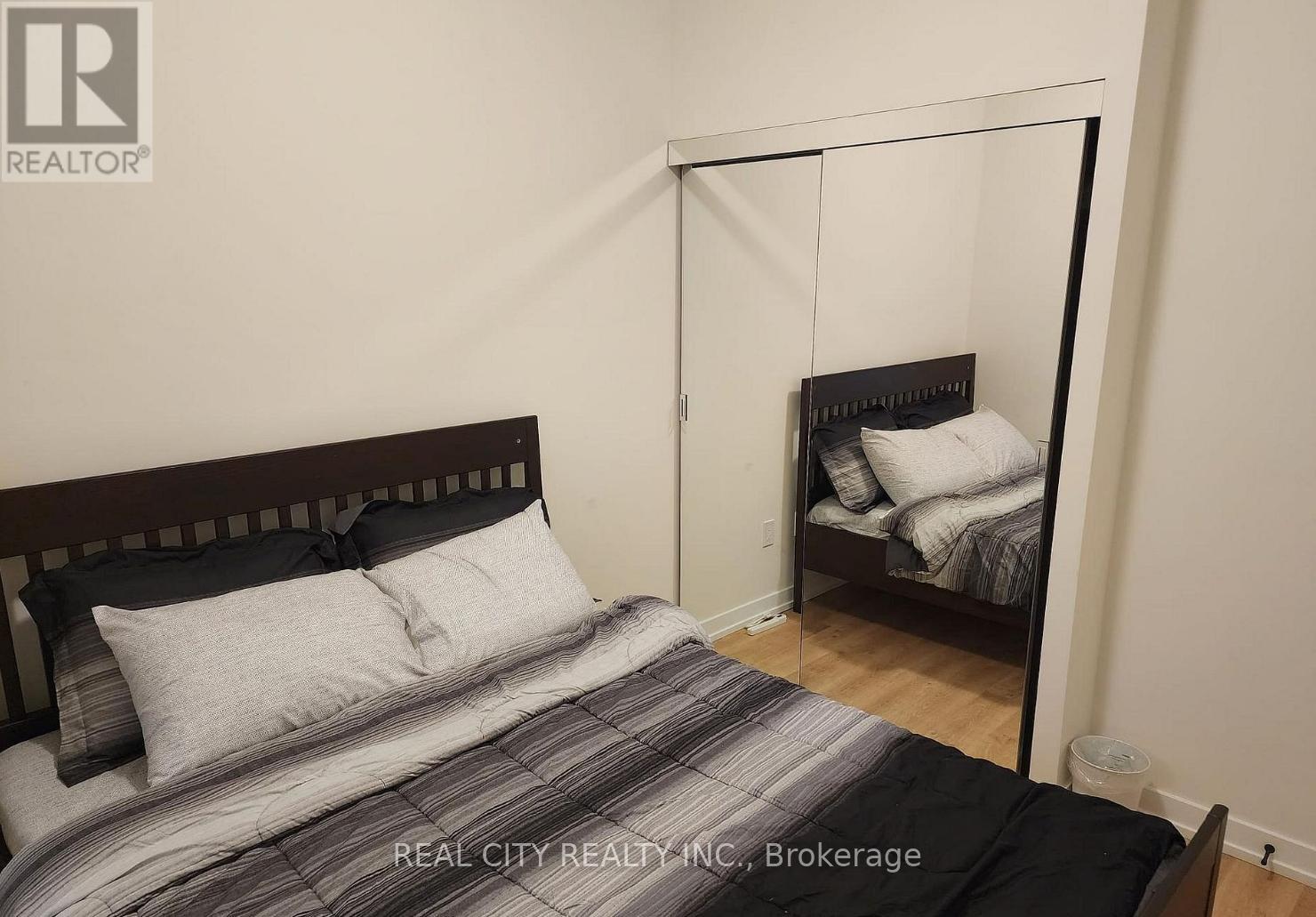 A bedroom with a bed and a mirror.