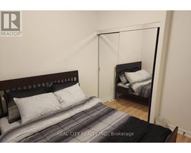 A bedroom with a bed and a mirror.