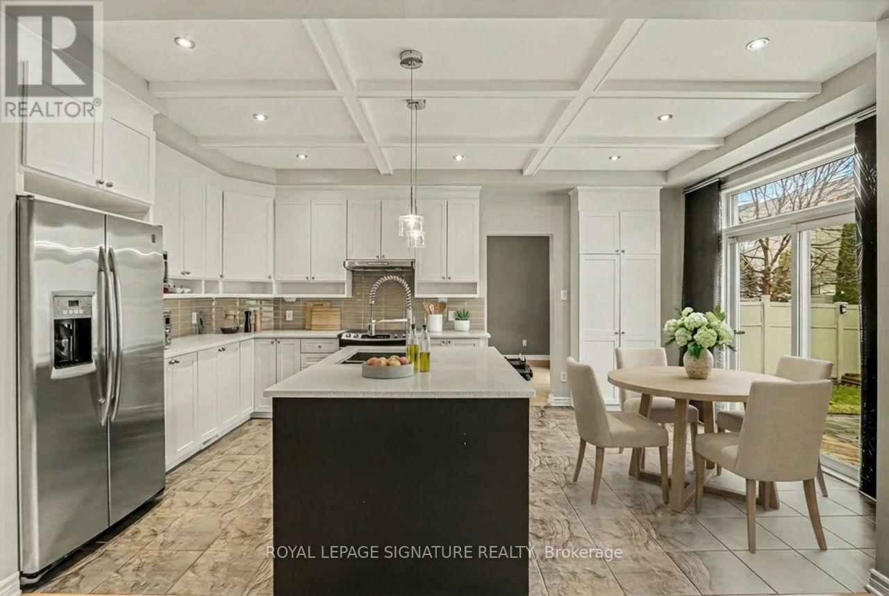 A modern kitchen with a large island and a dining table set for four.