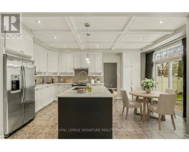 A modern kitchen with a large island and a dining table set for four.