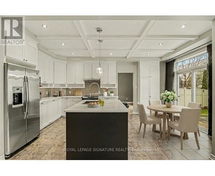 A modern kitchen with a large island and a dining table set for four.