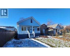 A blue house with a white fence in front of it.