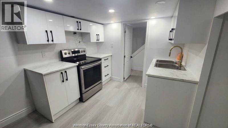 A kitchen with white cabinets and a black stove top oven.