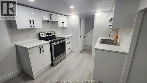 A kitchen with white cabinets and a black stove top oven.