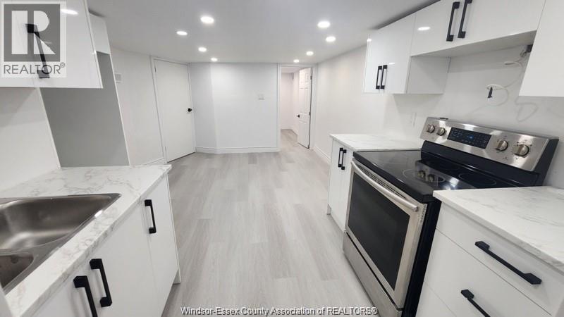 A modern kitchen with white cabinets and stainless steel appliances.