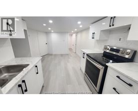 A modern kitchen with white cabinets and stainless steel appliances.