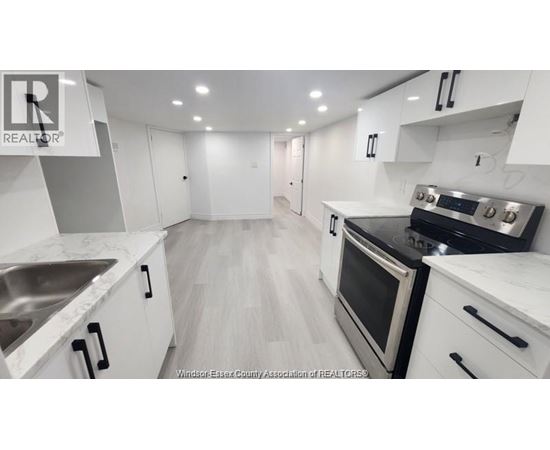 A modern kitchen with white cabinets and stainless steel appliances.