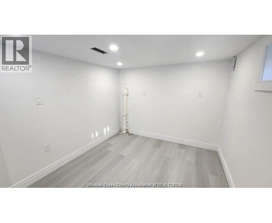 A room with white walls and a wooden floor.