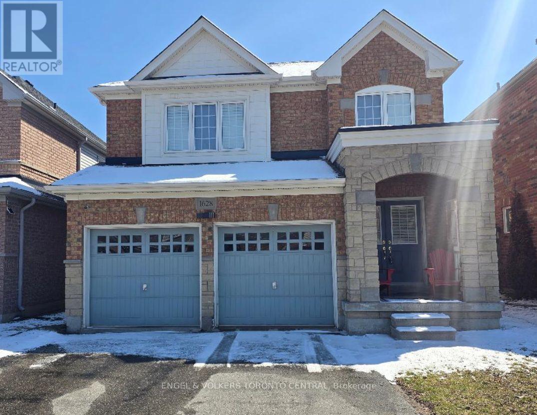 A house with a garage and a driveway in front of it.