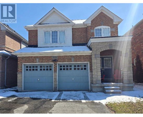 A house with a garage and a driveway in front of it.