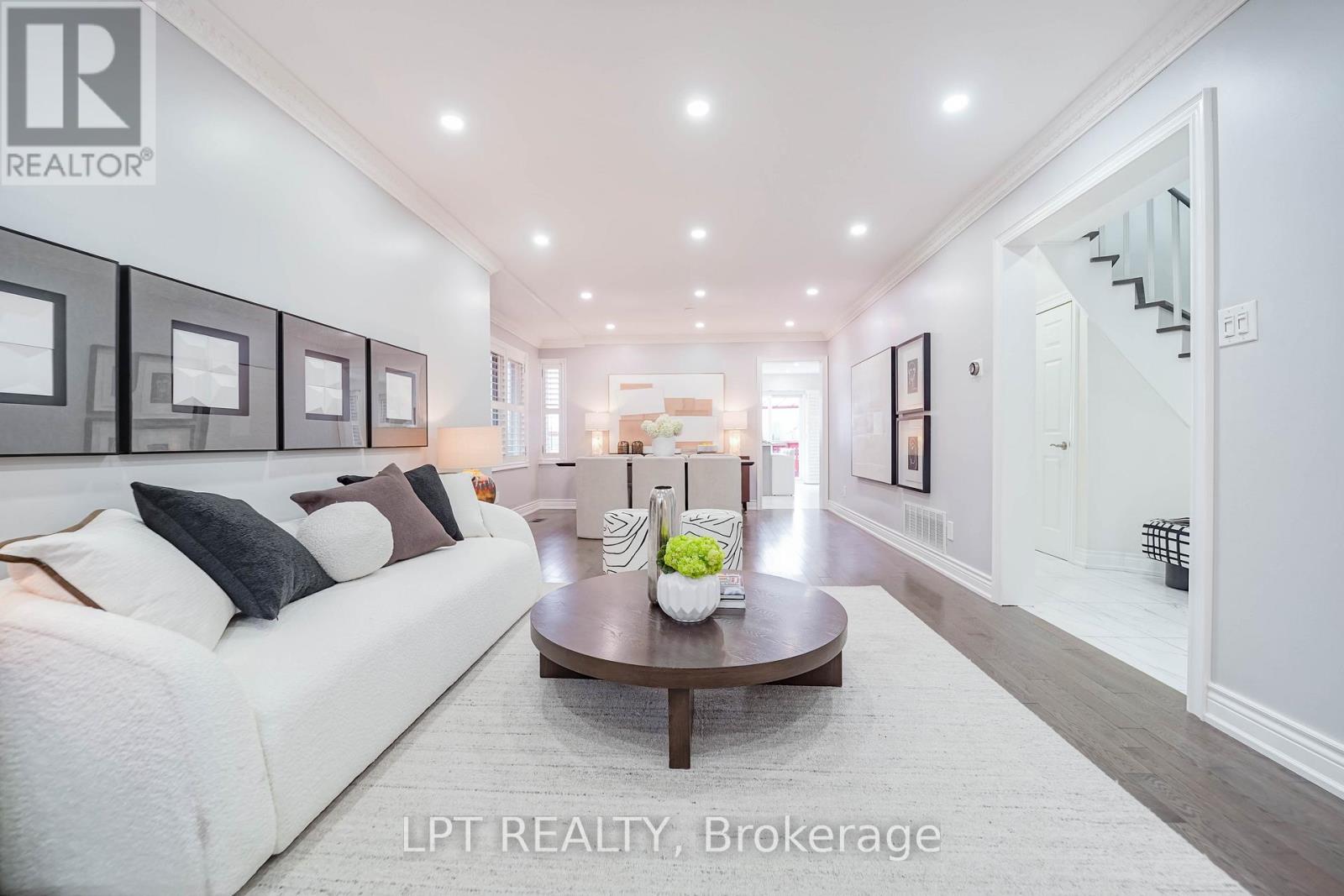 A spacious living room with a white sofa and a coffee table.