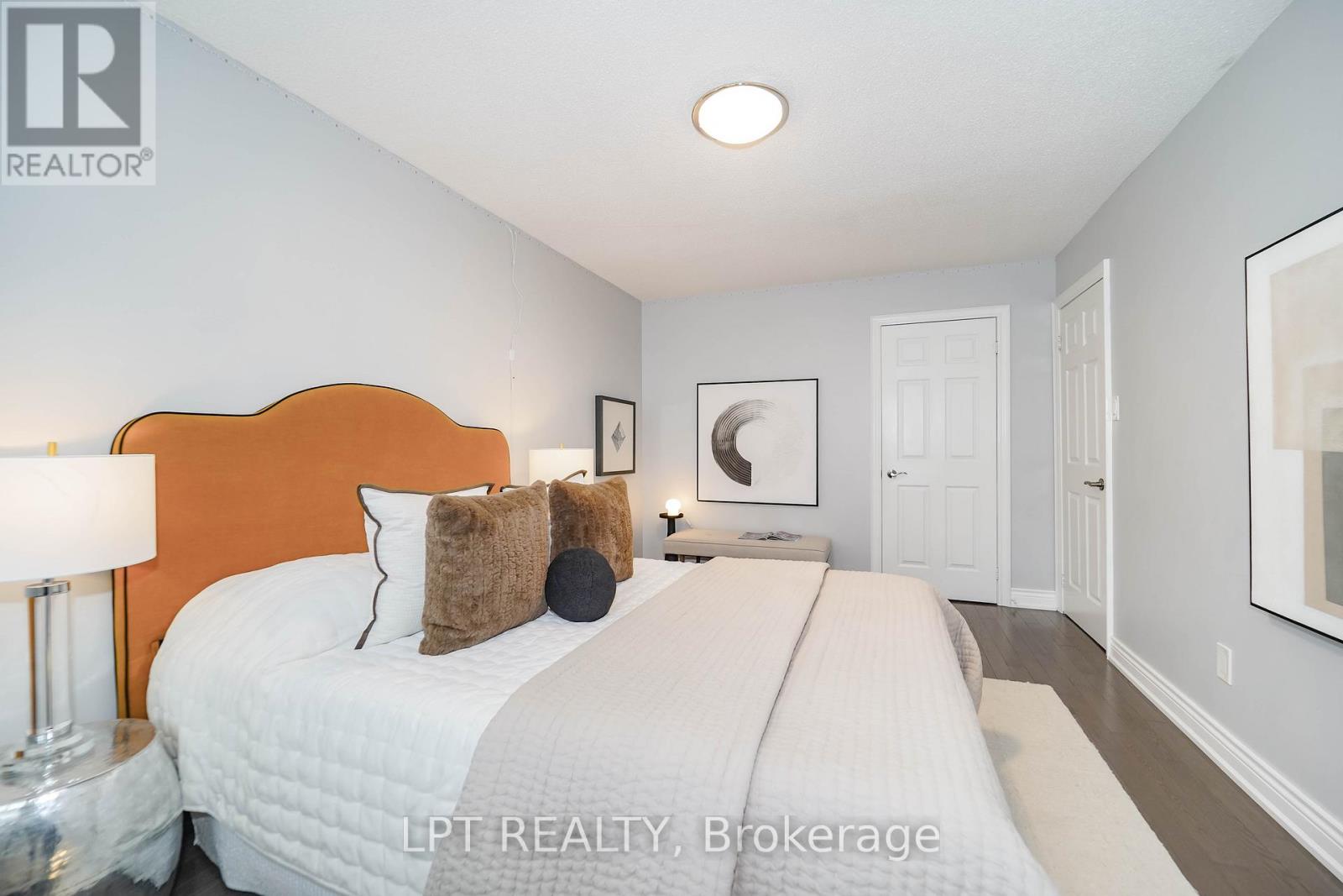 A bedroom with a large bed and a lamp on the side table.
