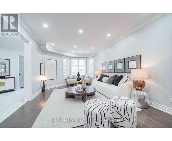 A well-lit, modern living room with a white sofa, a coffee table, and a large window.