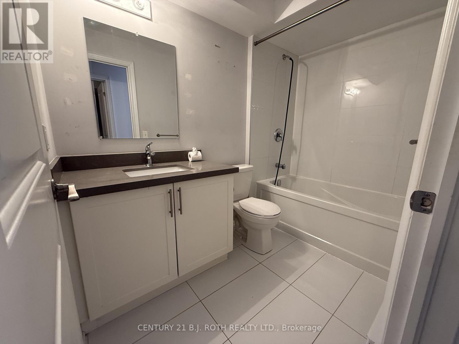 A bathroom with a toilet, sink, and bathtub.
