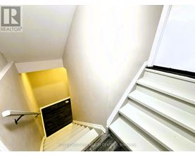A staircase with a yellow wall on the side.