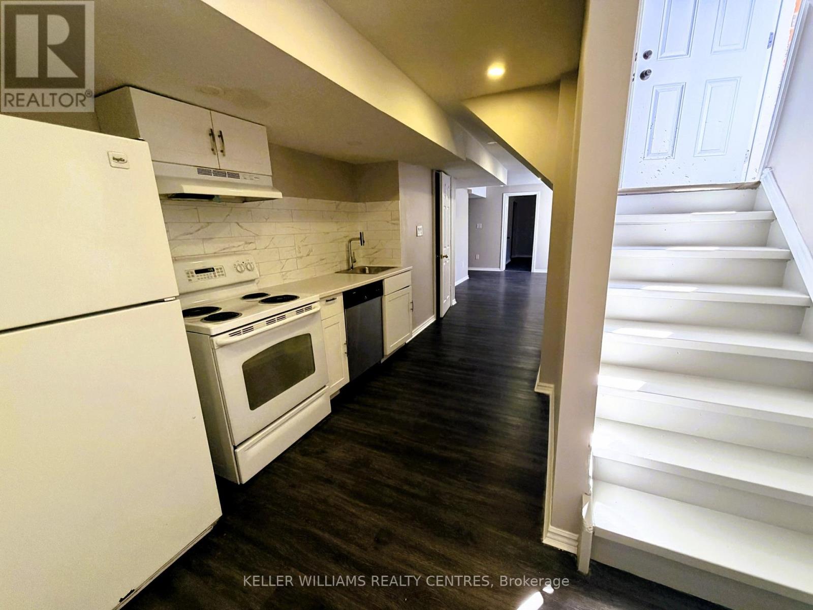 A white kitchen with a white fridge and stove.