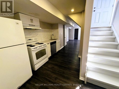 A white kitchen with a white fridge and stove.