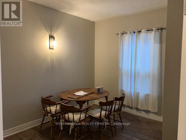 A dining room with a wooden table and chairs.