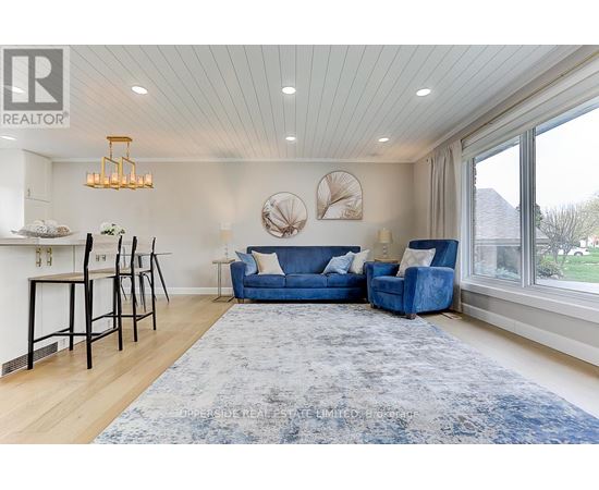 A living room with a blue couch and a rug.